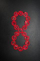 figure eight (8) lined with red condom on a black background