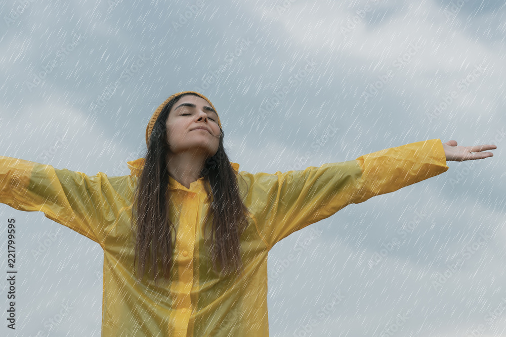 Wall mural Woman wearing yellow raincoat out in the rain