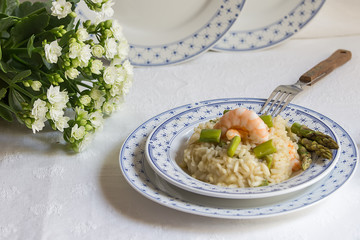 Delicious Italian risotto with shrimps and asparagus on a light background