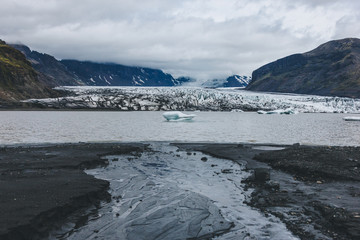 beautiful glacier Skaftafellsjkull and snowy mountains against cloudy sky in Skaftafell National Park in Iceland