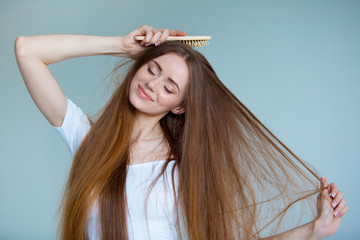 Beauty close-up portrait of beautiful young woman with long brown hair on white background. Hair care concept.