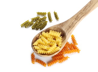 Colorful Italian spiral shaped pasta, macaroni in wooden spoon isolated on white background