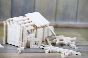 Toy wooden house. The constructor is made of natural wood for children. Wooden toy house of small blocks of a constructor.