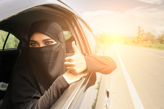 Saudi Woman Driving A Car On The Road. Muslim Woman Driver Concept