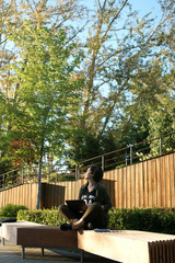 Fototapeta premium Young woman working in a quiet courtyard of an office building