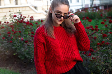 Close-up portrait of beautiful caucasian woman walking outdoors. Beautiful woman in a sweater. Fashion portrait stylish pretty woman outdoor. Young woman having fun in city. Street fashion.