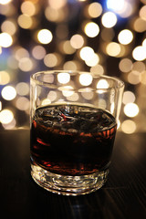 glass of alcohol with ice on blured background with circle bokeh