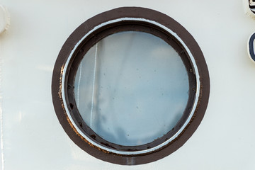 The porthole in the ship's cabin is outside