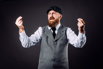 A bearded man in suit talking and gesticulating like italian on black background