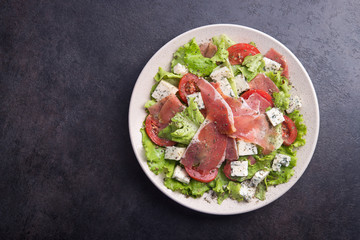 Fresh salad with prosciutto, tomato, lettuce and cheese blue