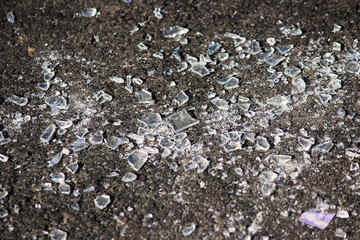 transparent shards of a windshield from the car on asphalt of parking.