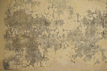 Faded yellow ancient crumbling plaster stucco wall horizontal background