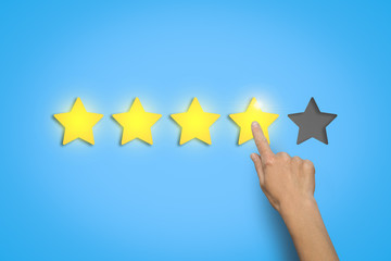 Female hand leaves a rating of four stars out of five possible o