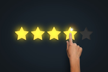 Female hand leaves a rating of four stars out of five possible o