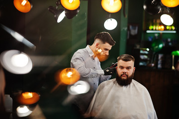 Handsome bearded man at the barbershop, barber at work.