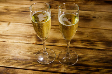 Two glasses of champagne on wooden table