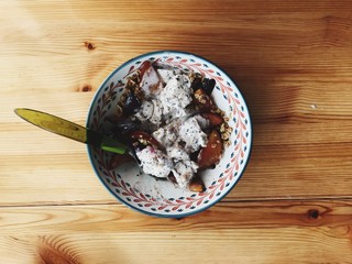 Plum crumble served in a bowl with ice cream