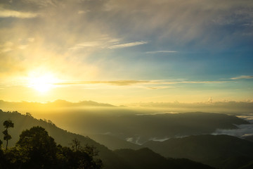 Obraz premium Fog in mountains, fantasy and colorful nature landscape and ray of sunlight through clouds, view from the top view of mountains. 