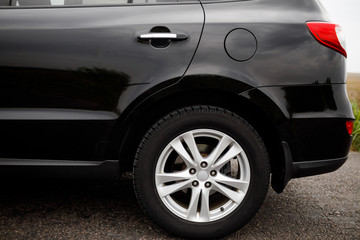 Car wheel close-up. Black modern car closeup. 