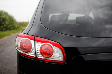 Black premium city crossover, luxury SUV rear light closeup.