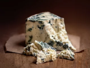 Tuinposter Blue cheese Gorgonzola on a rustic wooden background. Mold cheese with copyspace © nataliazakharova
