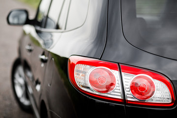 Obraz premium Black premium city crossover, luxury SUV rear light closeup.