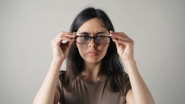 girl with glasses isolated on grey wall background.