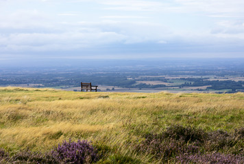 Lonely wooden bench on the top with beautiful view of mountain and farm view at countryside in north of England, Top view of large field in gloomy day