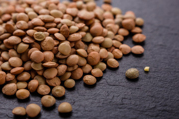 raw lentils on a dark stone background
