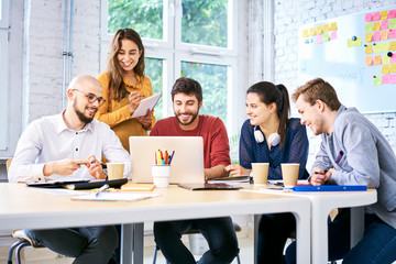 Attractive students using laptop and studying together. Startup entrepreneurs at work