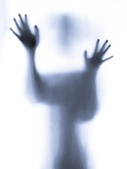 Screaming human pressing through fabric curtain as horror background . Trapped in shadows