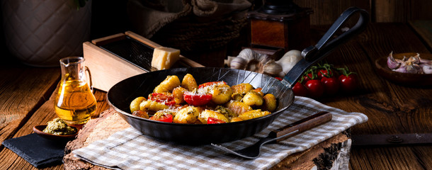 gnocchi baked with green pesto, cherry tomatoes and parmesan