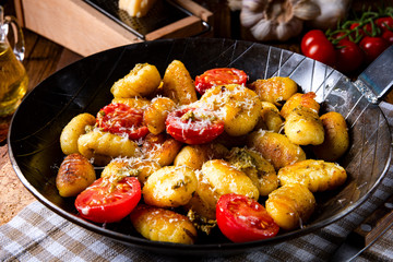 gnocchi baked with green pesto, cherry tomatoes and parmesan