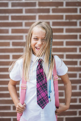 Happy cute schoolgirl posing in a street