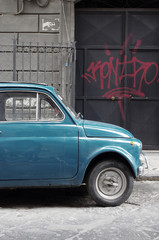 Fiat car near wall of graffiti