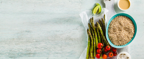banner of grain Sorghum or great milet with green asparagus and cherry tomatoes on the table. ingredients for gluten-free recipes. healthy cuisine for people with celiac disease