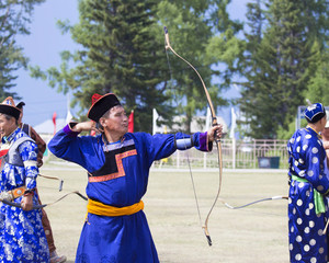 Young man shoots from a sports bow