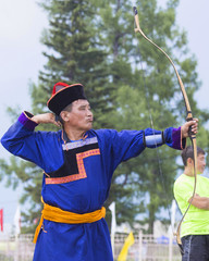 Young man shoots from a sports bow