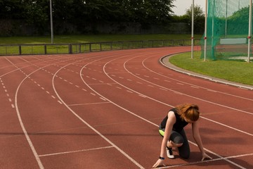 Female athlete ready to run on running track