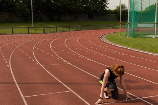 Female athlete ready to run on running track