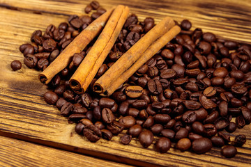 Coffee beans and cinnamon sticks on rustic wooden background