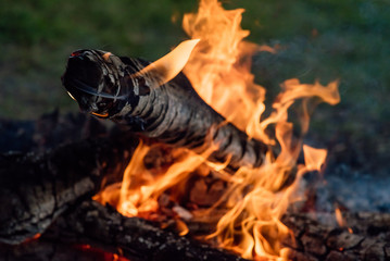 Flame burns in the fire. Fire in the grill with smoke. Arson or natural disaster. The fire is close. Fire in nature. Background bonfire