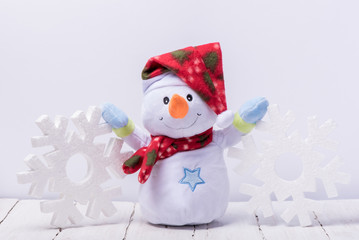 Funny snowman with big snowflakes from foam on a white background