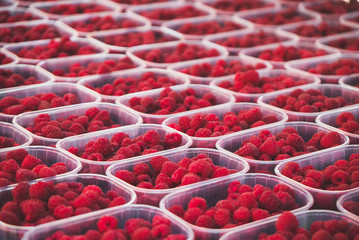 Lot of ripe red raspberries in the supermarket.