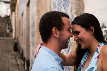 a happy couple looking at each other on the wall of a street.