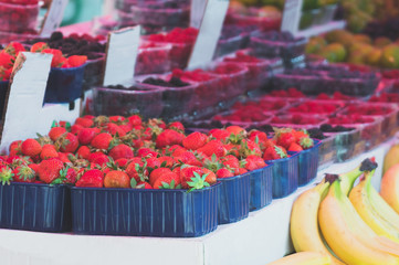 Lot of ripe berries in the market. Strawberries and raspberries.