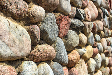 natural stone wall of round stone, front and back background blurred with bokeh effect
