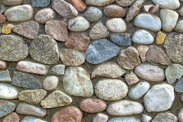 natural stone wall of round stone, front and back background blurred with bokeh effect