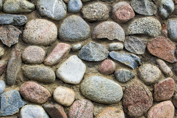 natural stone wall of round stone, front and back background blurred with bokeh effect
