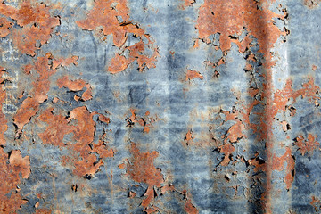 Close-up surface of old rusty barrel with shabby paint.